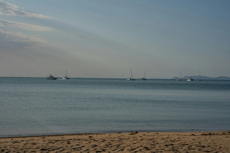 some boats out in the ocean on a sunny day