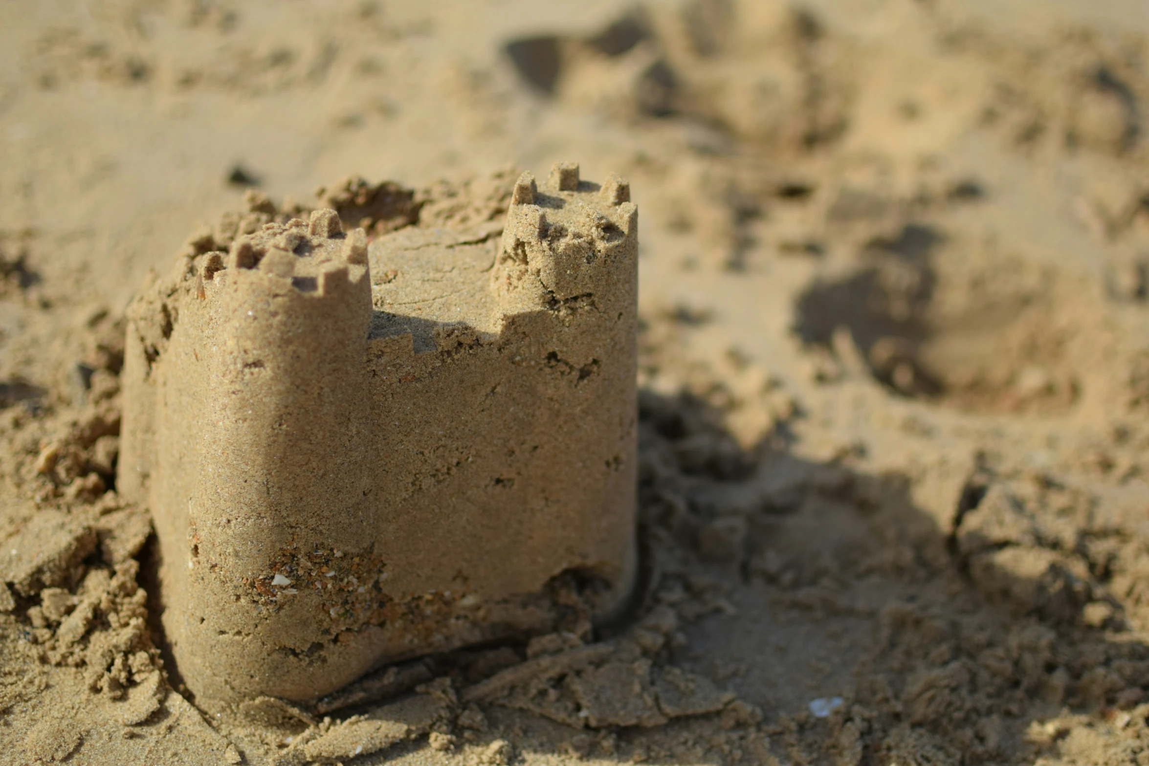 a sandcastle is on the beach that is broken