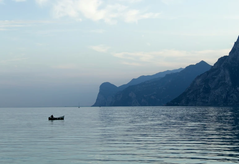 two people in a row boat on a large body of water