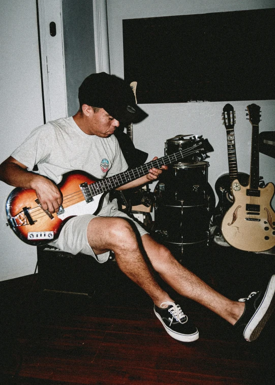 a man sitting on the floor playing guitar