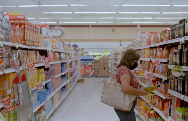 a woman shops for snacks in the aisle of a grocery store