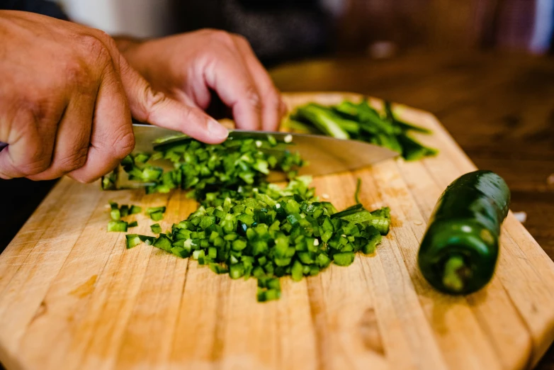 someone  green onions on a wooden board