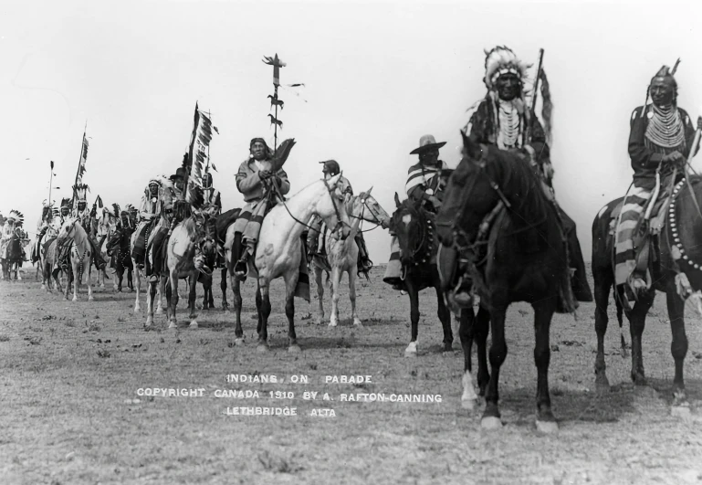 a group of men and women on horses in a field