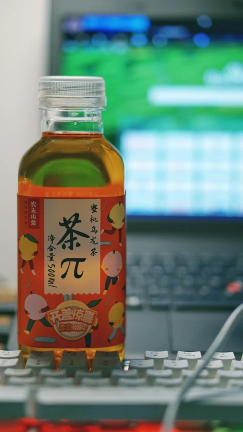 a bottle of water sitting next to a computer keyboard