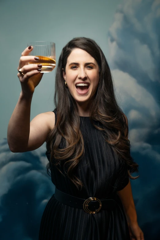 woman in black dress holding up glass