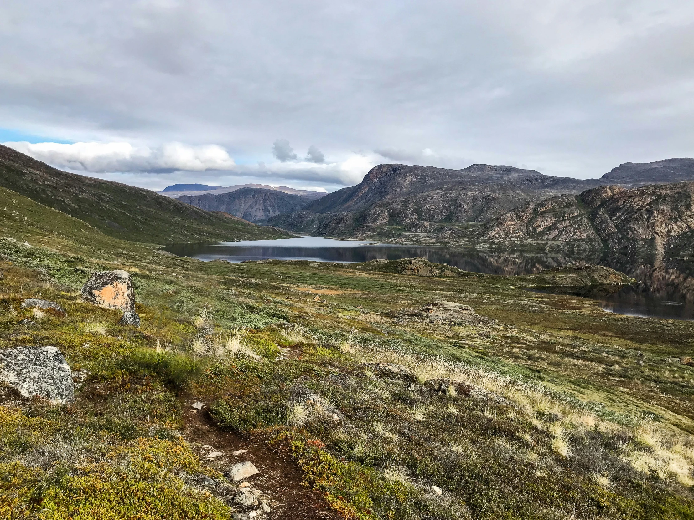 the sky is overcast, but there are mountains and hills