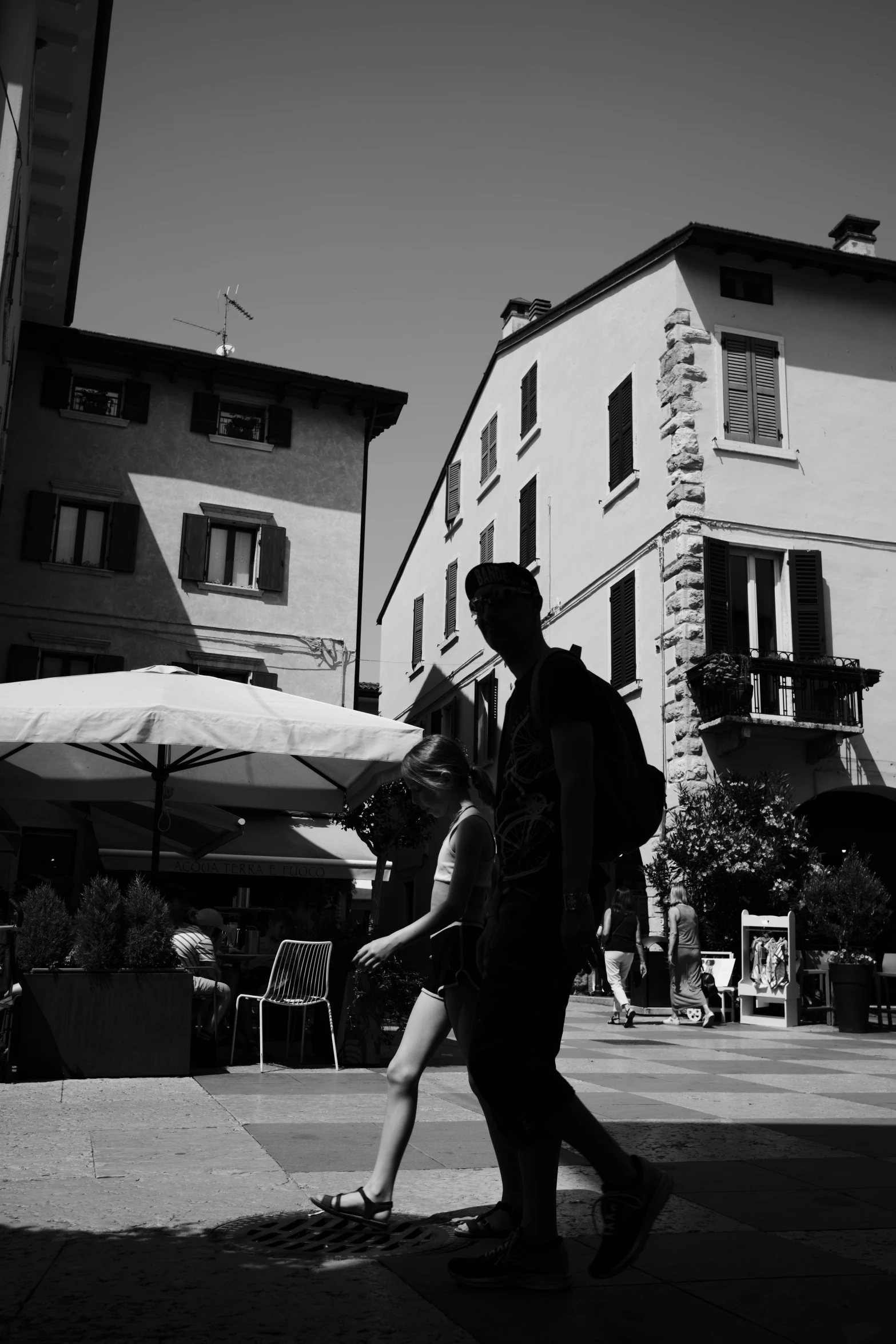 a man with a backpack walking down a sidewalk