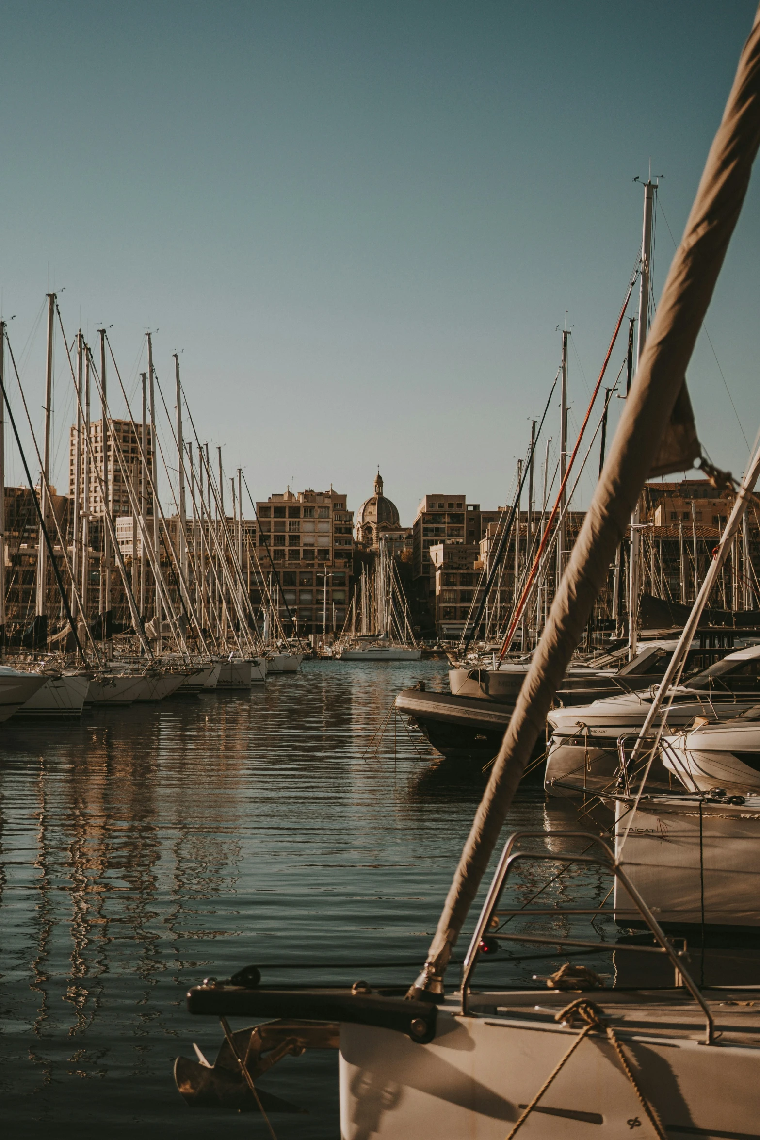 many boats are docked in the water near some buildings