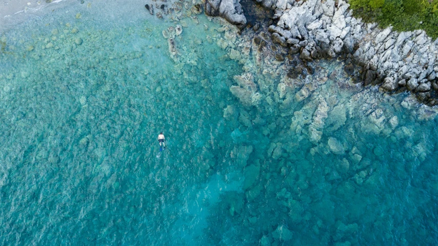 a view from above of a boat traveling in clear blue water