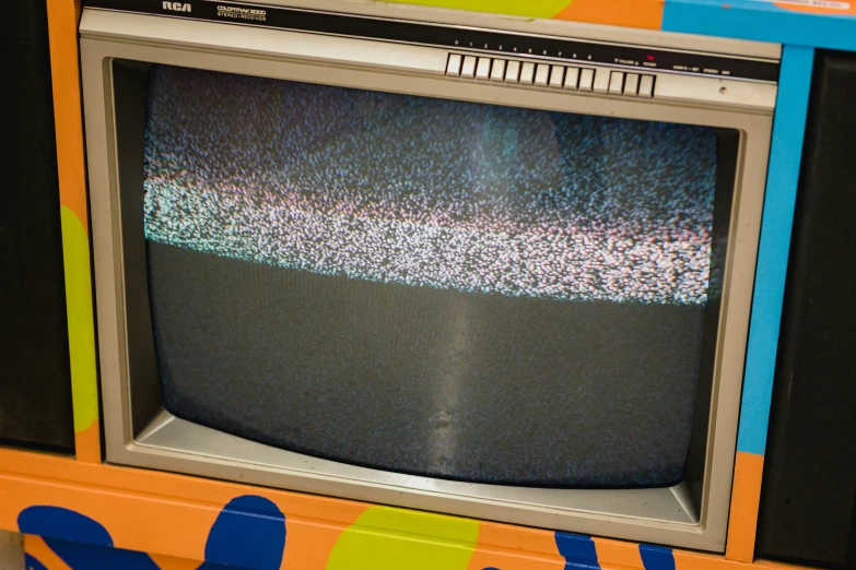 an old tv is turned on and sitting in front of an assortment of cds