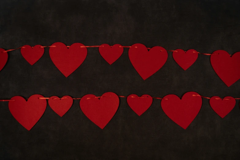 red hearts are lined up on a black table