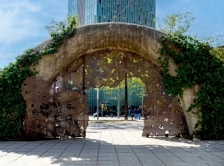 a gate with vines is open near a tall building