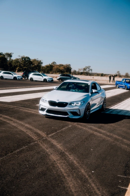 a sports car driving on a track with another car behind it