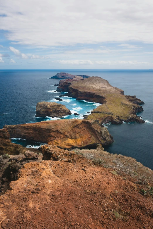 a large body of water sitting next to a rocky hillside