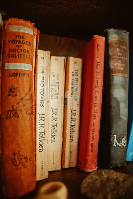 five books are sitting on a wooden table