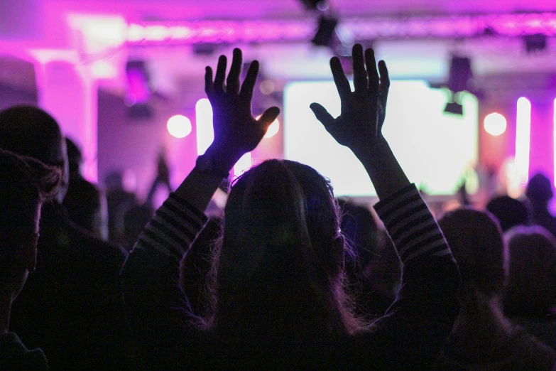 a person holding their hands up at a concert