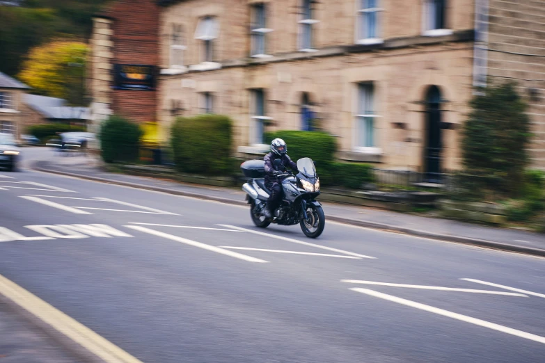 motorcyclist in full gear riding on a city street