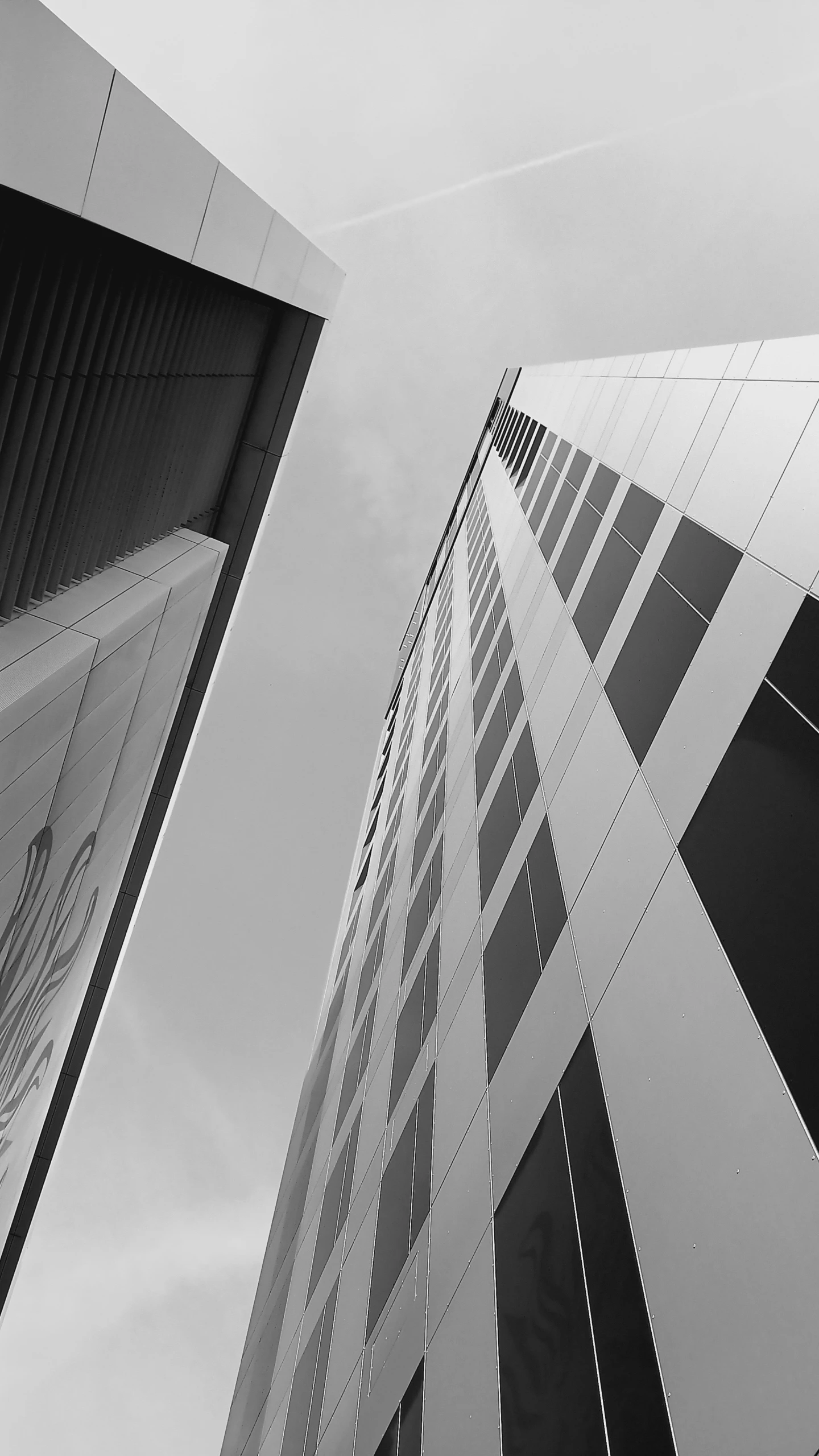 two buildings that are very tall and designed with many windows