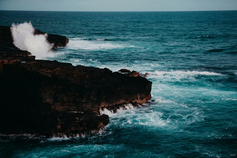 the waves crash against the rock outcroppings