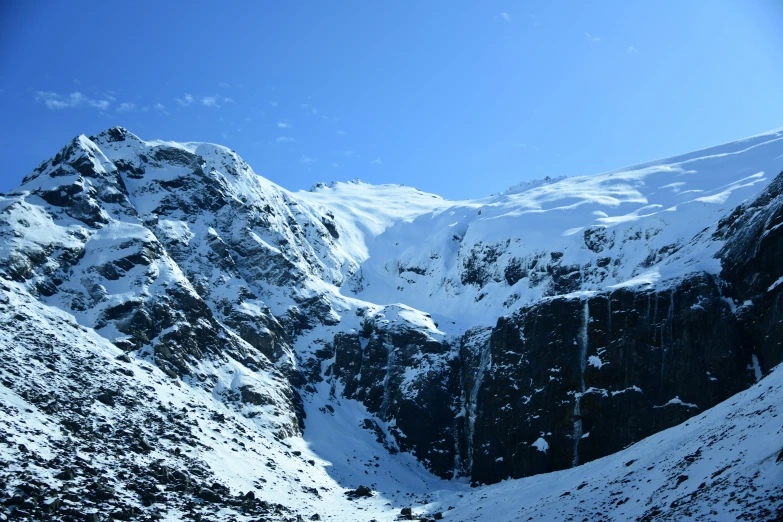 a mountain scene covered in snow and with the sky