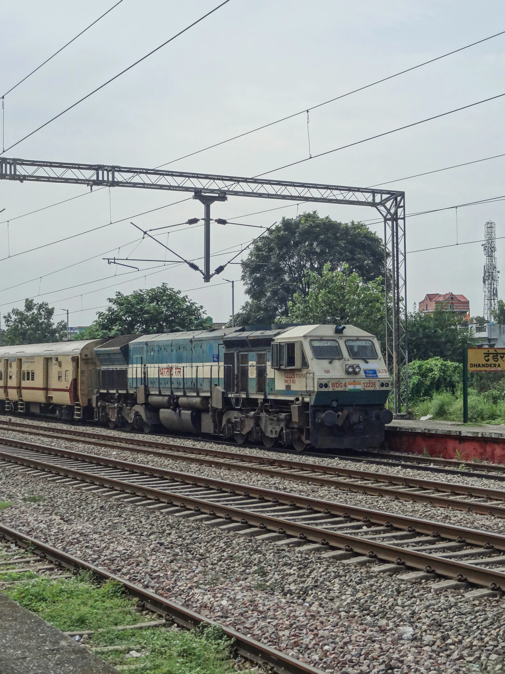 two trains on the train tracks surrounded by power lines