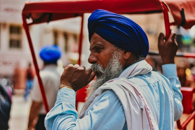 an indian man riding in a buggy carrying soing on his head