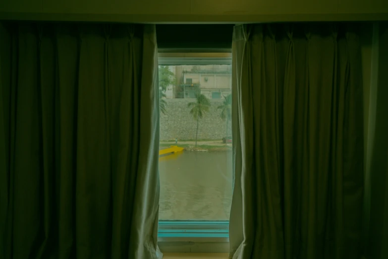 a window with curtains near the door leading to the water