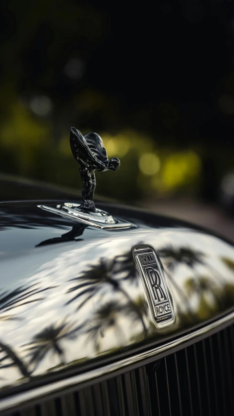 an old classic black car has a surfboard on the hood