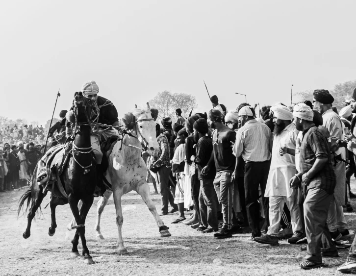 a man on horseback holding a spear with two legs while leading people