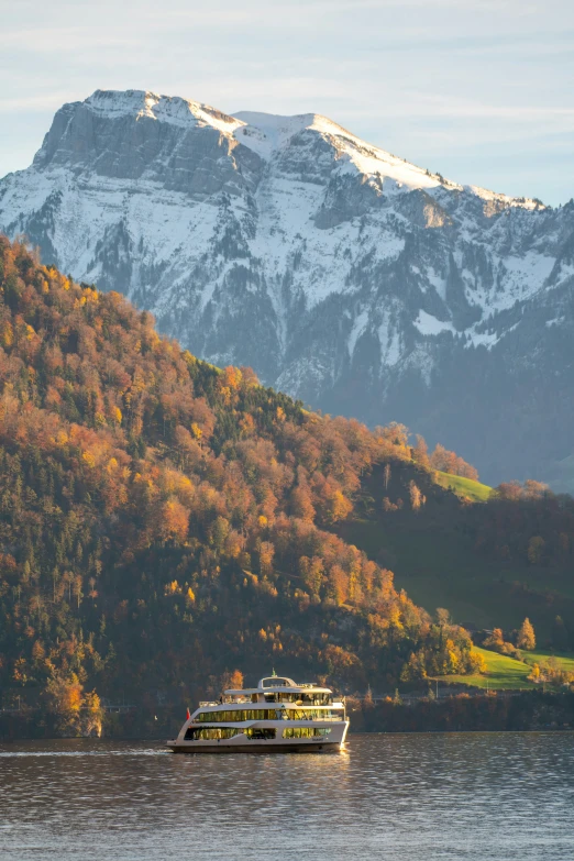 a boat floating on a lake near a mountain