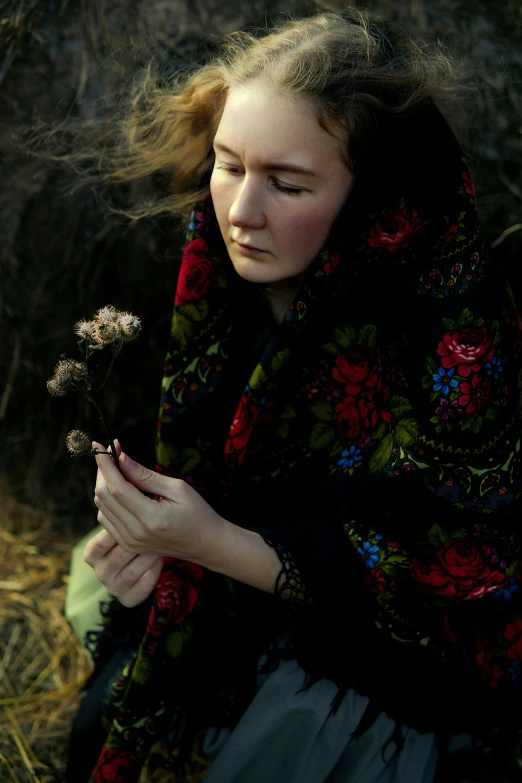 a woman kneeling down with her hand on her flower