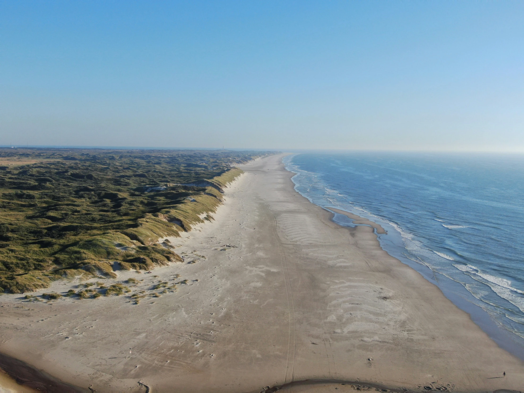 a long stretch of beach next to the ocean