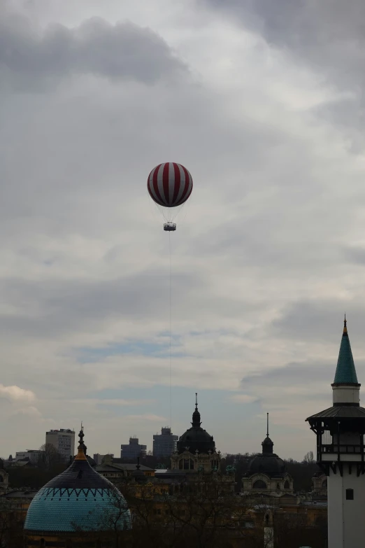 a kite flying high in the sky over some buildings