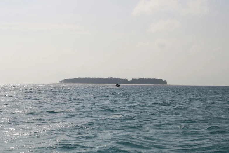 two people sitting on the boat in the ocean