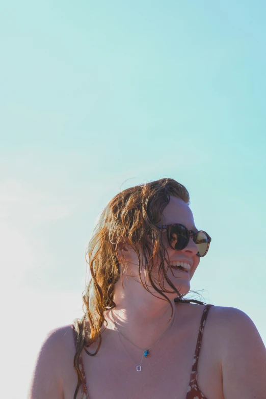 a woman smiling and wearing a swimsuit