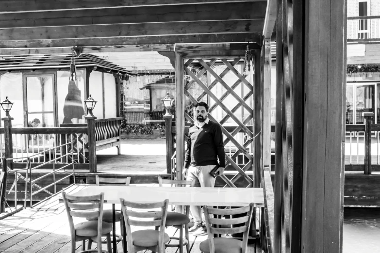 a man standing on a patio area next to some chairs