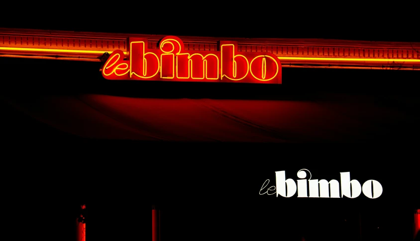 the neon sign shows the name of a business