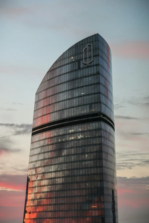 a tall building that has the sun setting on it