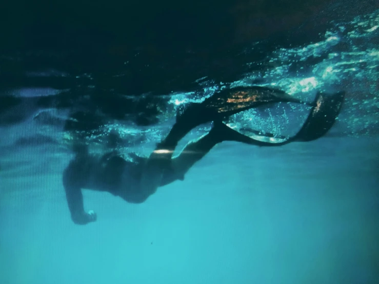 a person swimming under water with a mask