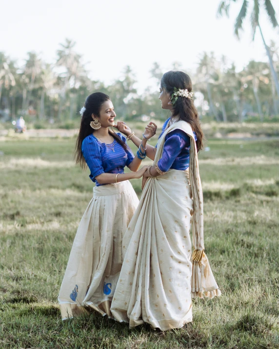 two woman are talking in a grassy field