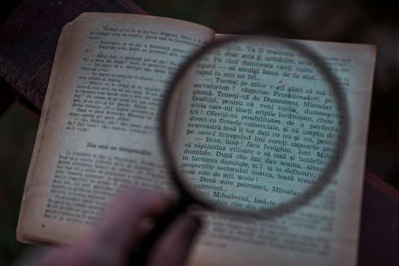 an old book is shown with a magnifying glass