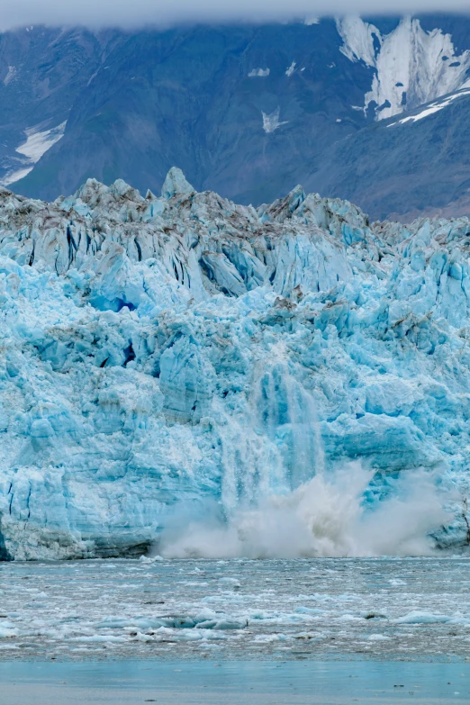 the water is spraying up blue and gray rocks