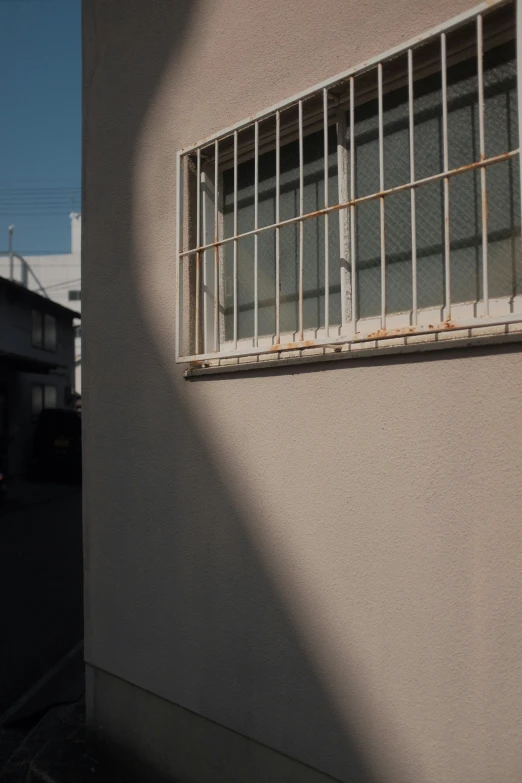 window in building, sun shining through bars in wall