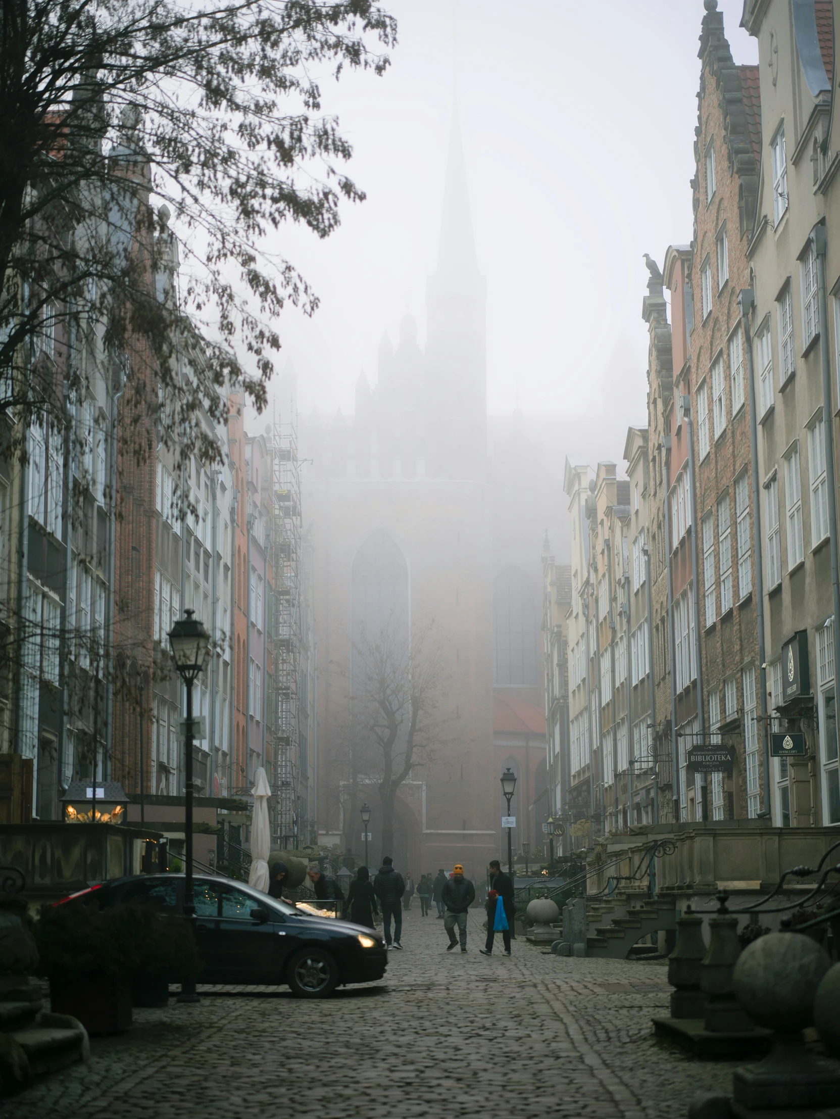 people walk through a foggy city street