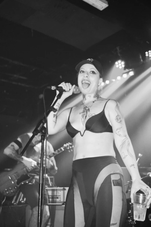 a woman with tattoos in underwear standing on a stage