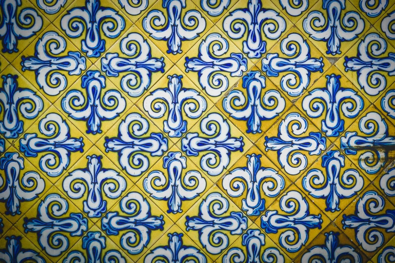 a tiled wall has blue swirls on it