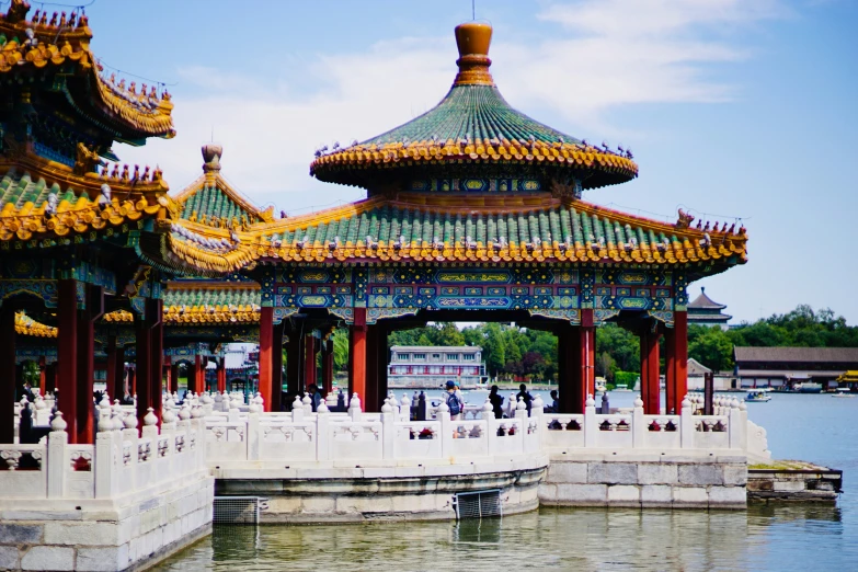 a pavilion is surrounded by water and with gold decorations