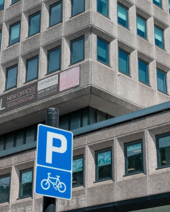 a blue parking sign hanging off the side of a pole