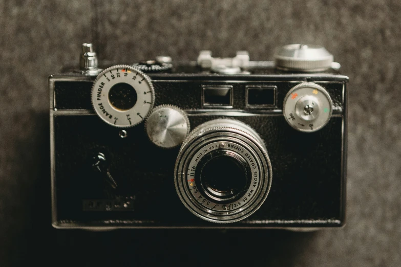 a old camera sitting on a black surface