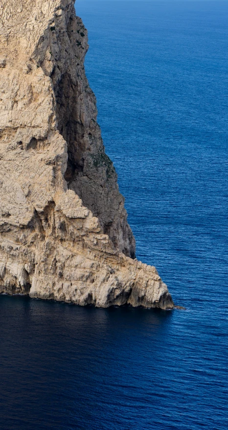 a big cliff in the middle of some ocean